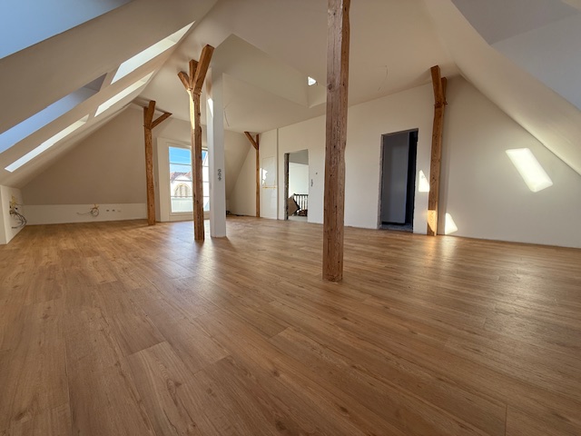 Neuverlegter Designbelag im Dachgeschoss eines Altbauobjekts in Holzoptik. Passgenaue Zuschneidung an Balken und Pfeilern mitten im Raum.